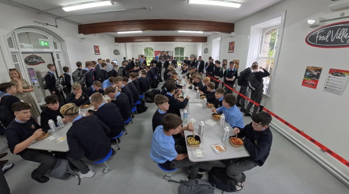 Students enjoying Food Village school meals during a busy lunchtime service in a secondary school.